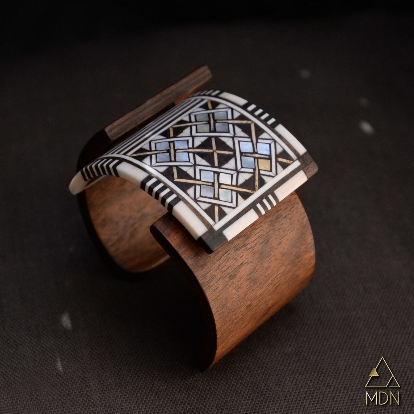 Cuff with geometric mosaic inlay pattern and wood backing.