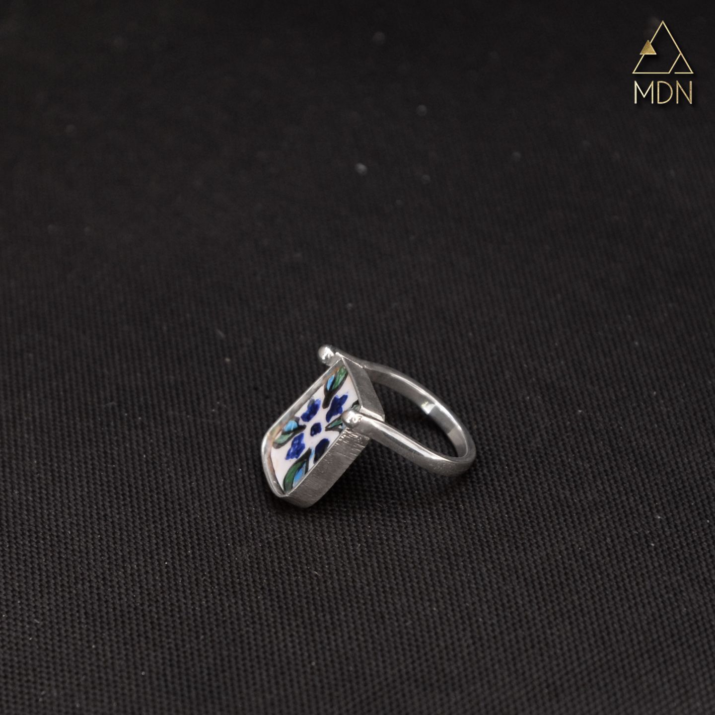 Rectangular mosaic inlay ring with blue and white design.