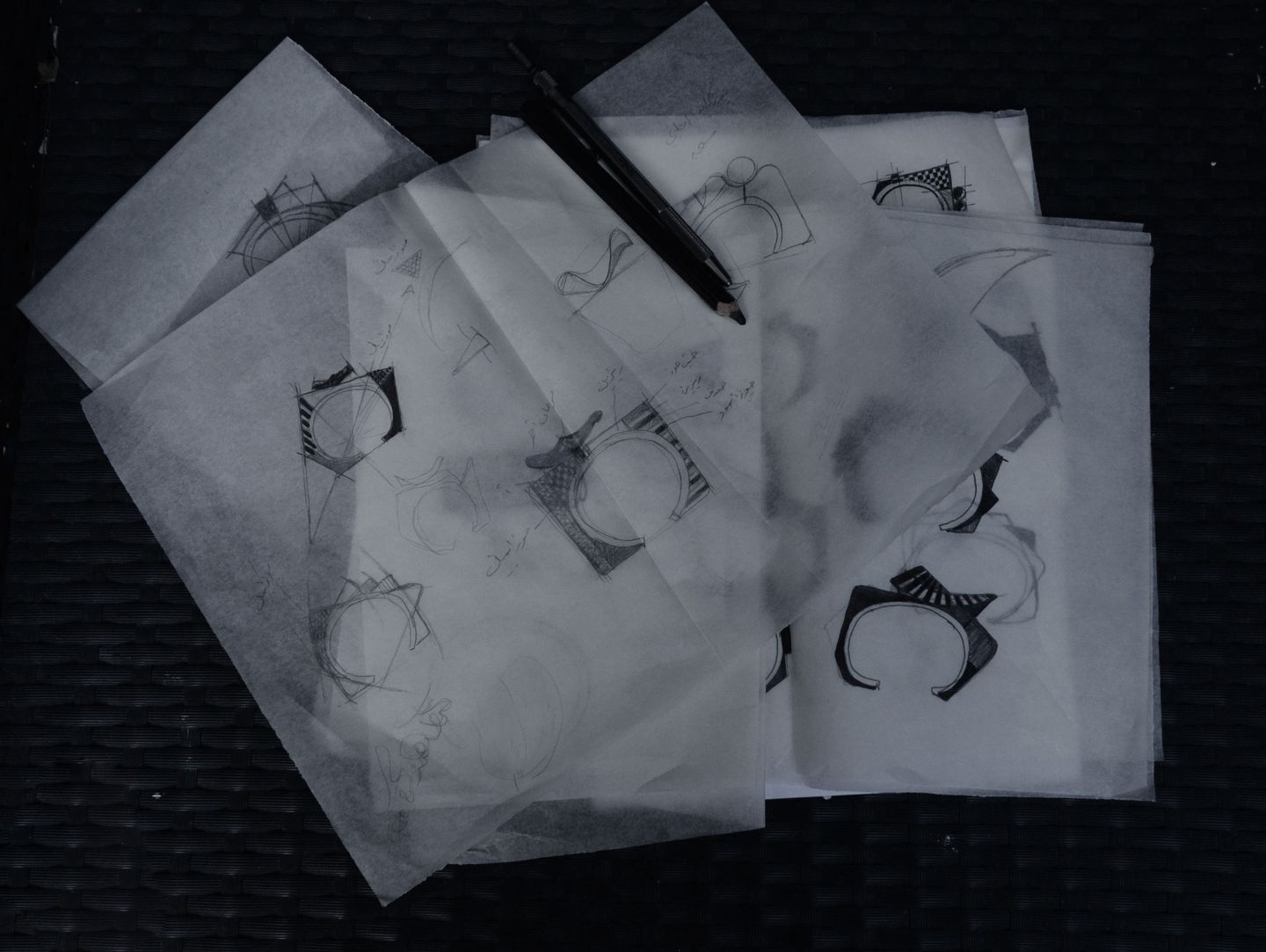 Sketches of jewelry designs with geometric patterns on paper.