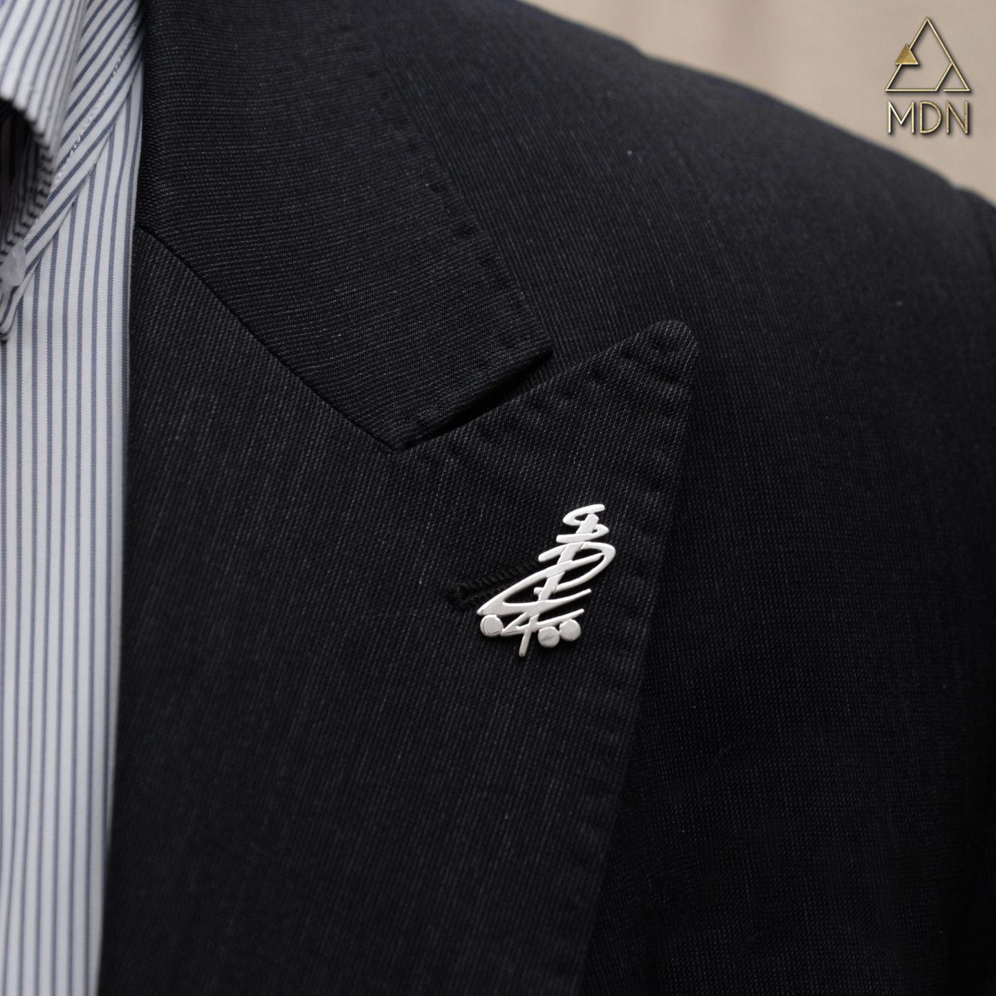 Brooch rendering the name Adib in Arabic calligraphy.