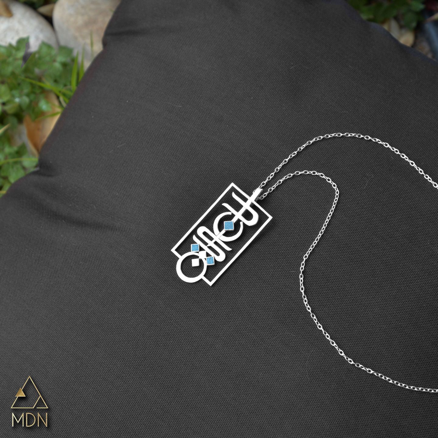 Pendant rendering the name Dania in Arabic calligraphy.