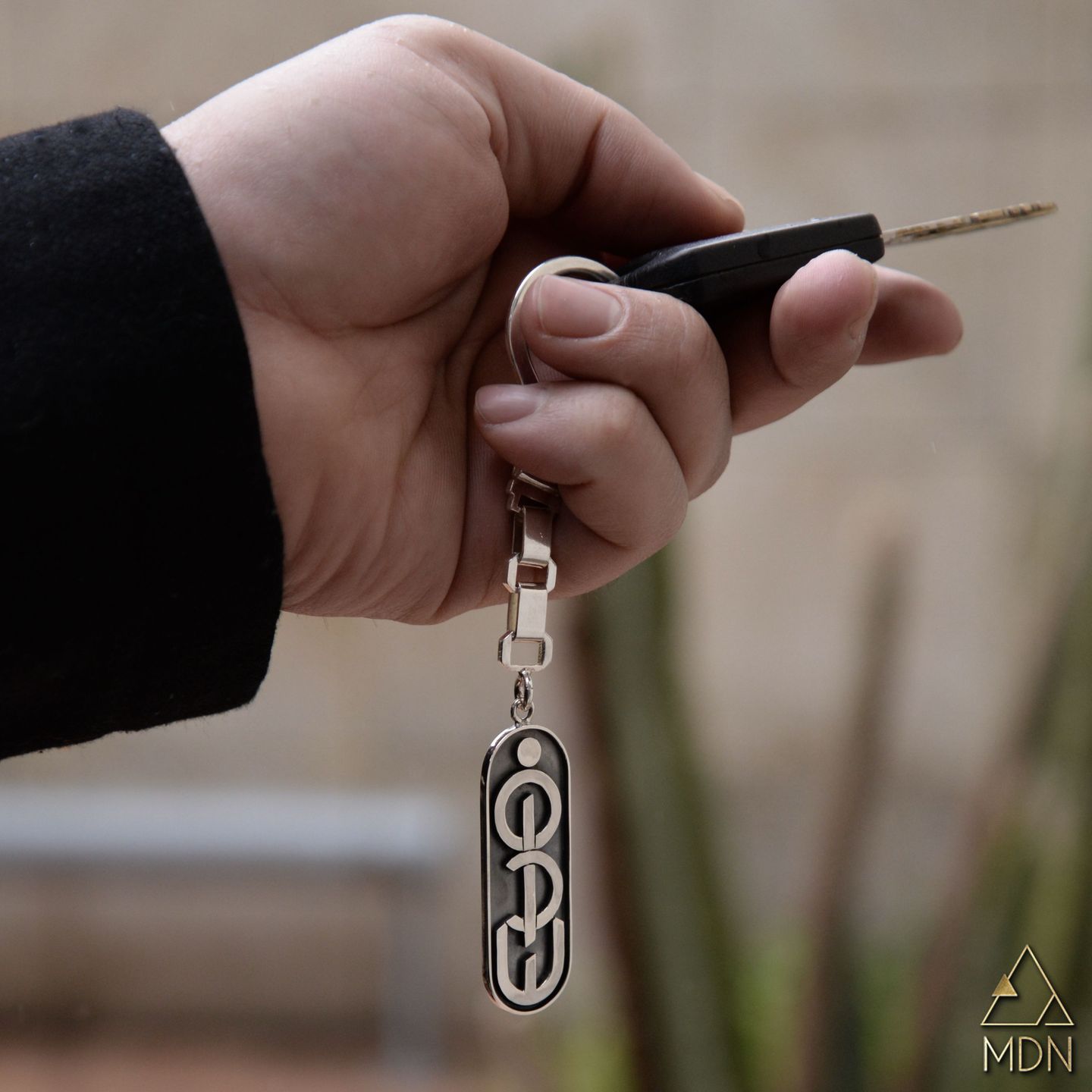 Keychain rendering the name Firas in Arabic calligraphy.