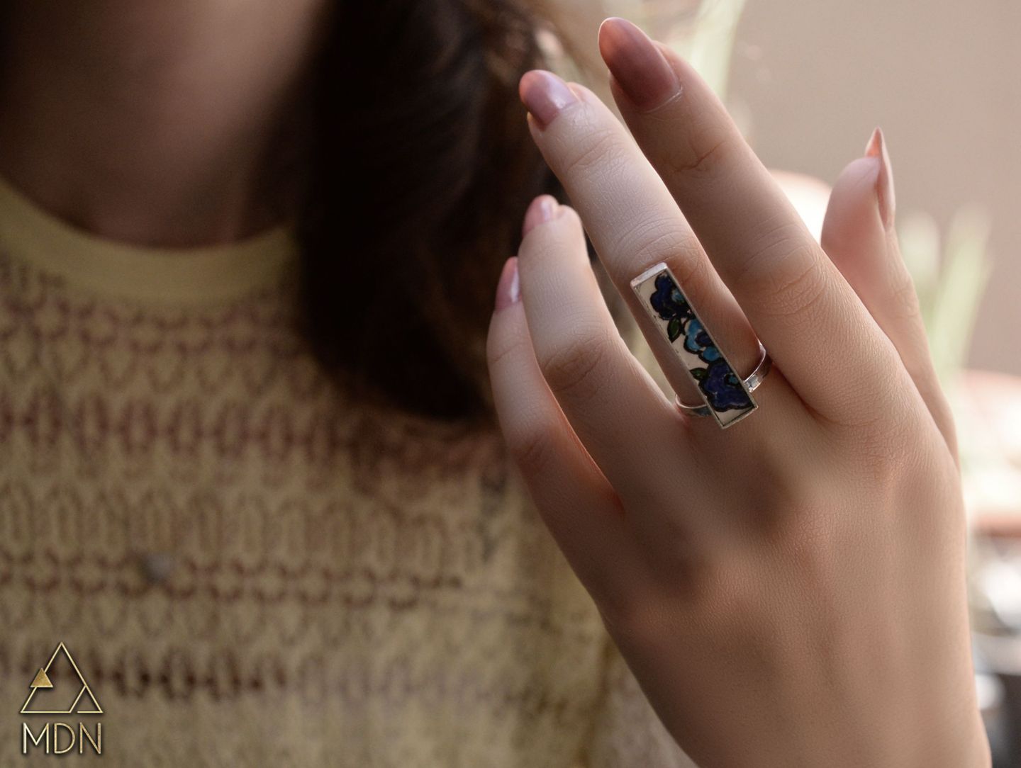 Mosaic inlay ring with blue and white geometric pattern.