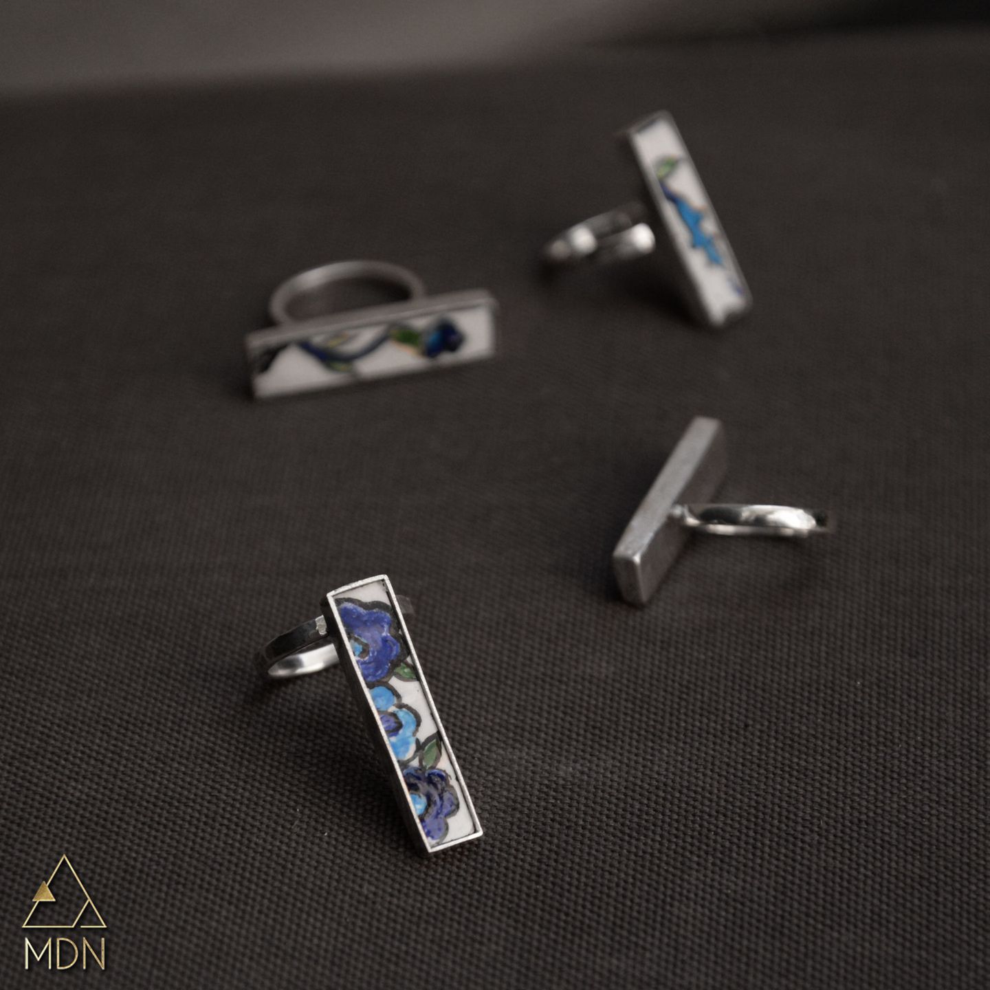 Mosaic inlay rings with blue and white patterns.