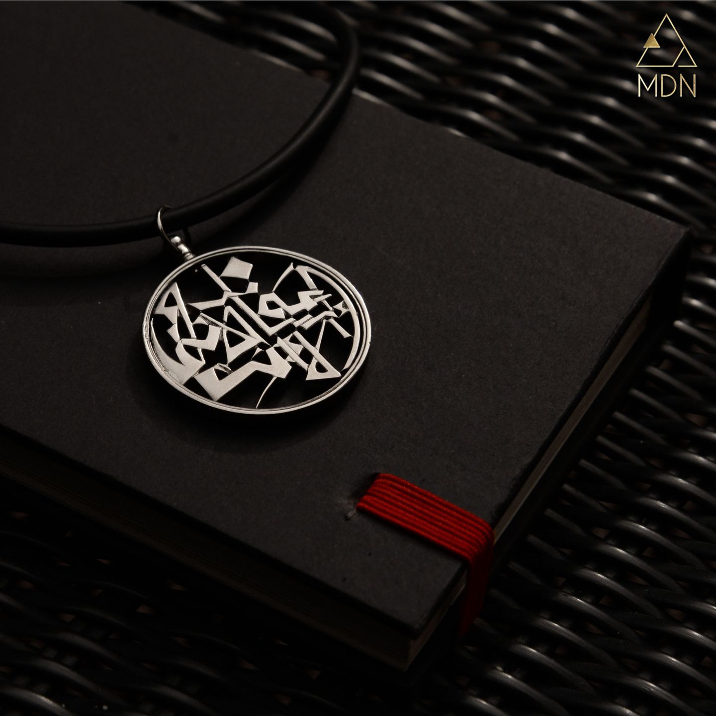 Circular pendant with Arabic calligraphy.