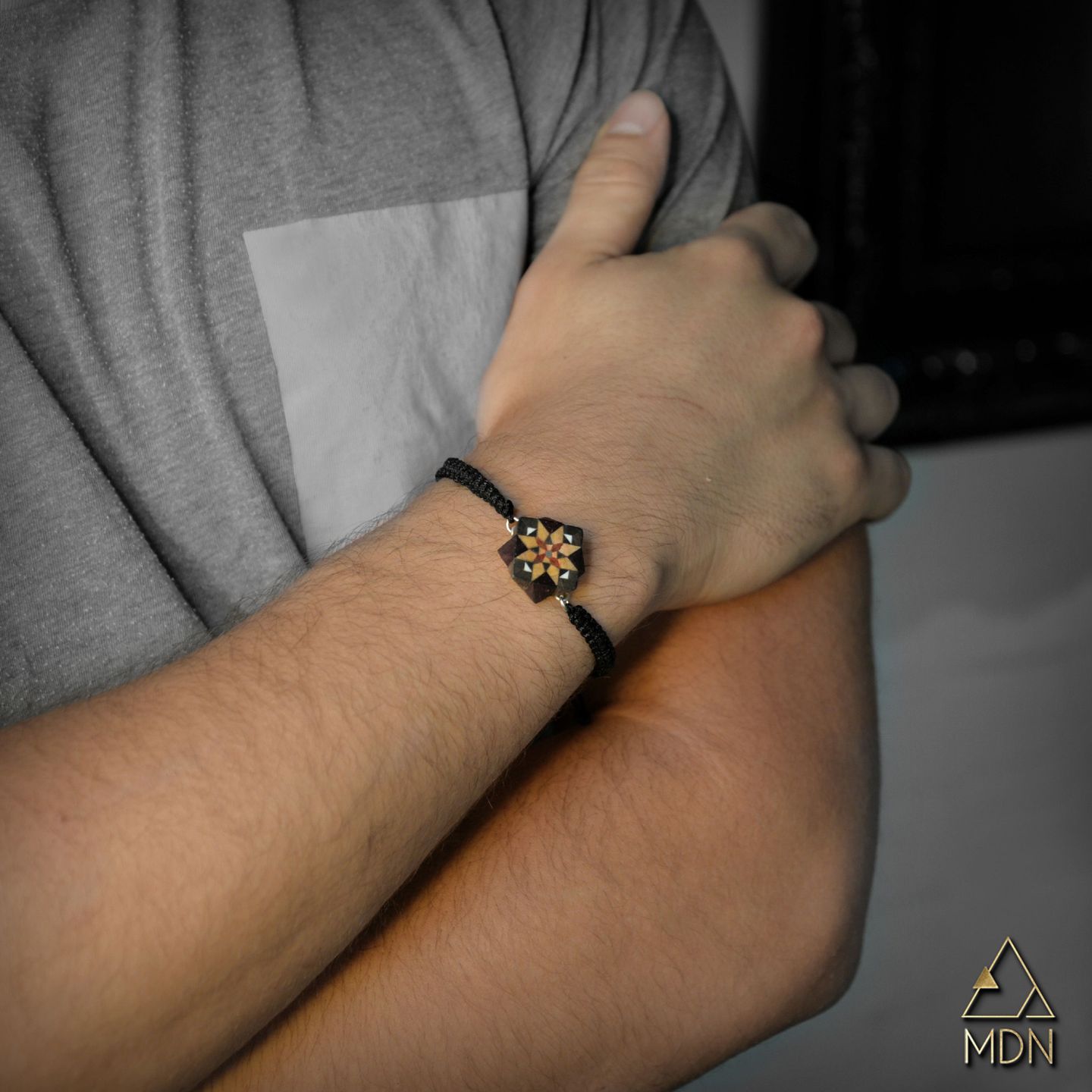 Men's bracelet with black cord and gold-toned charm