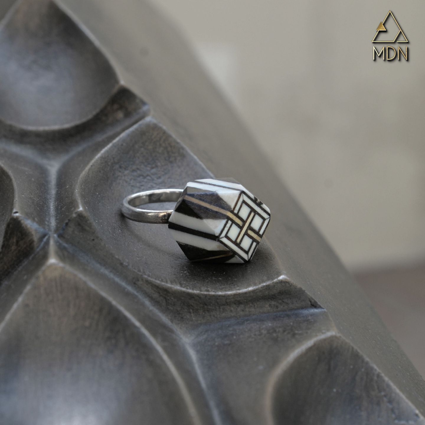 Ring with silver-toned band and striped geometric inlay