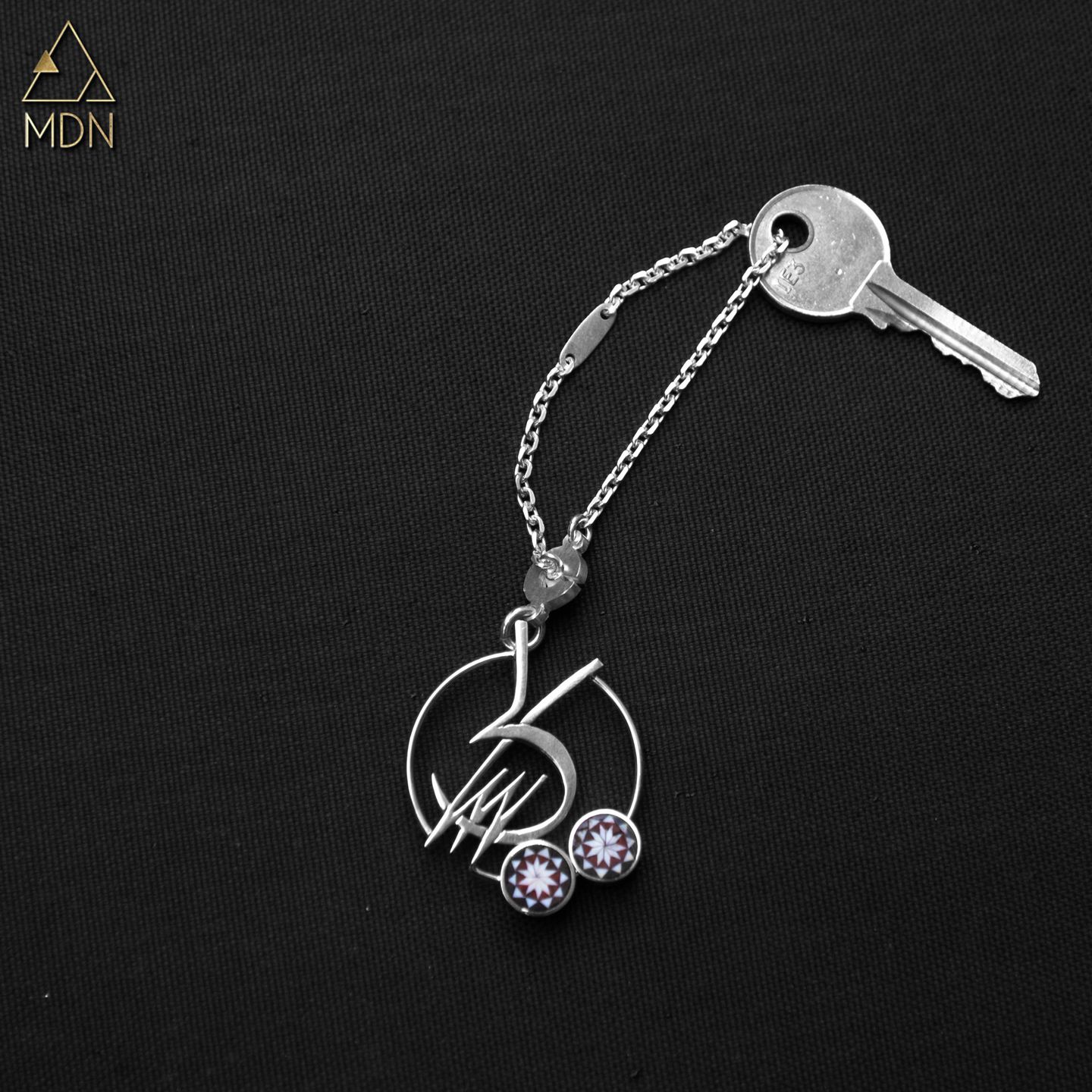 Keychain rendering the name Sally in Arabic calligraphy with purple stones.