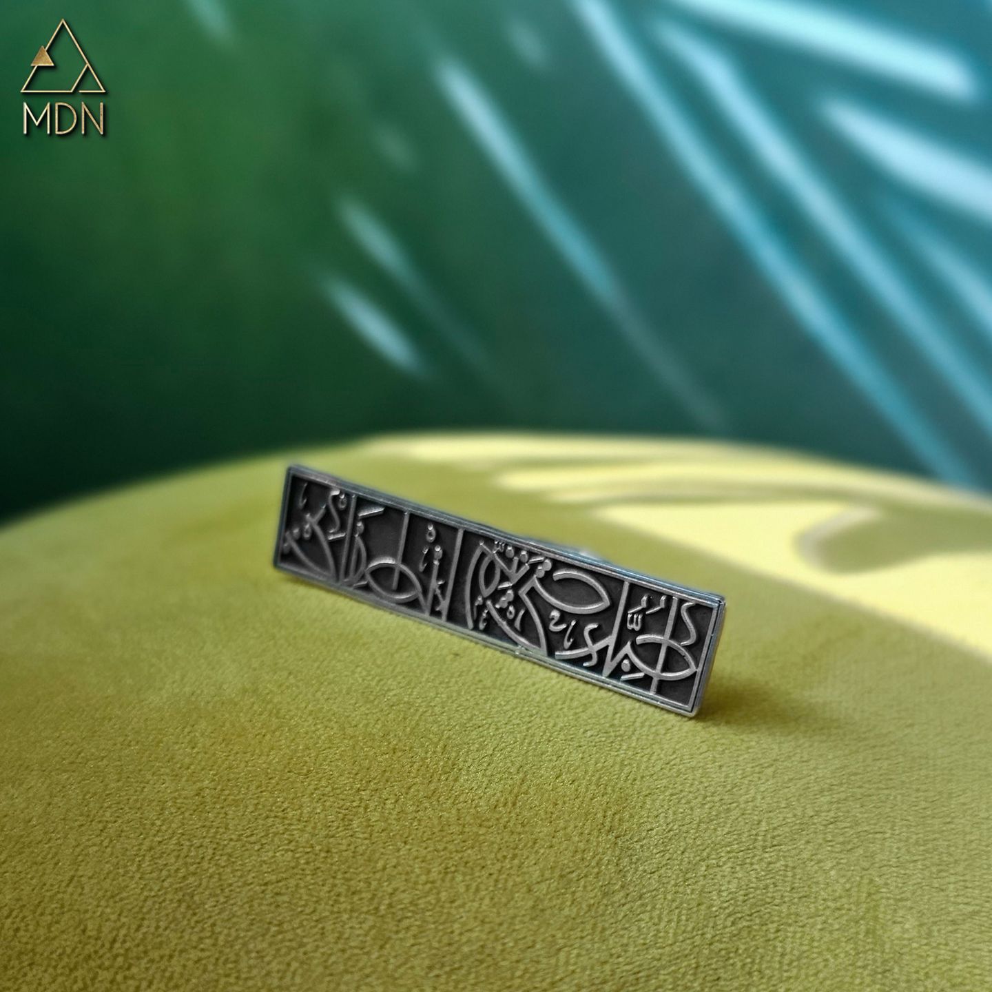 Cuff with Arabic calligraphy "احبك حتى يتم انطفائي" in silver-toned metal.