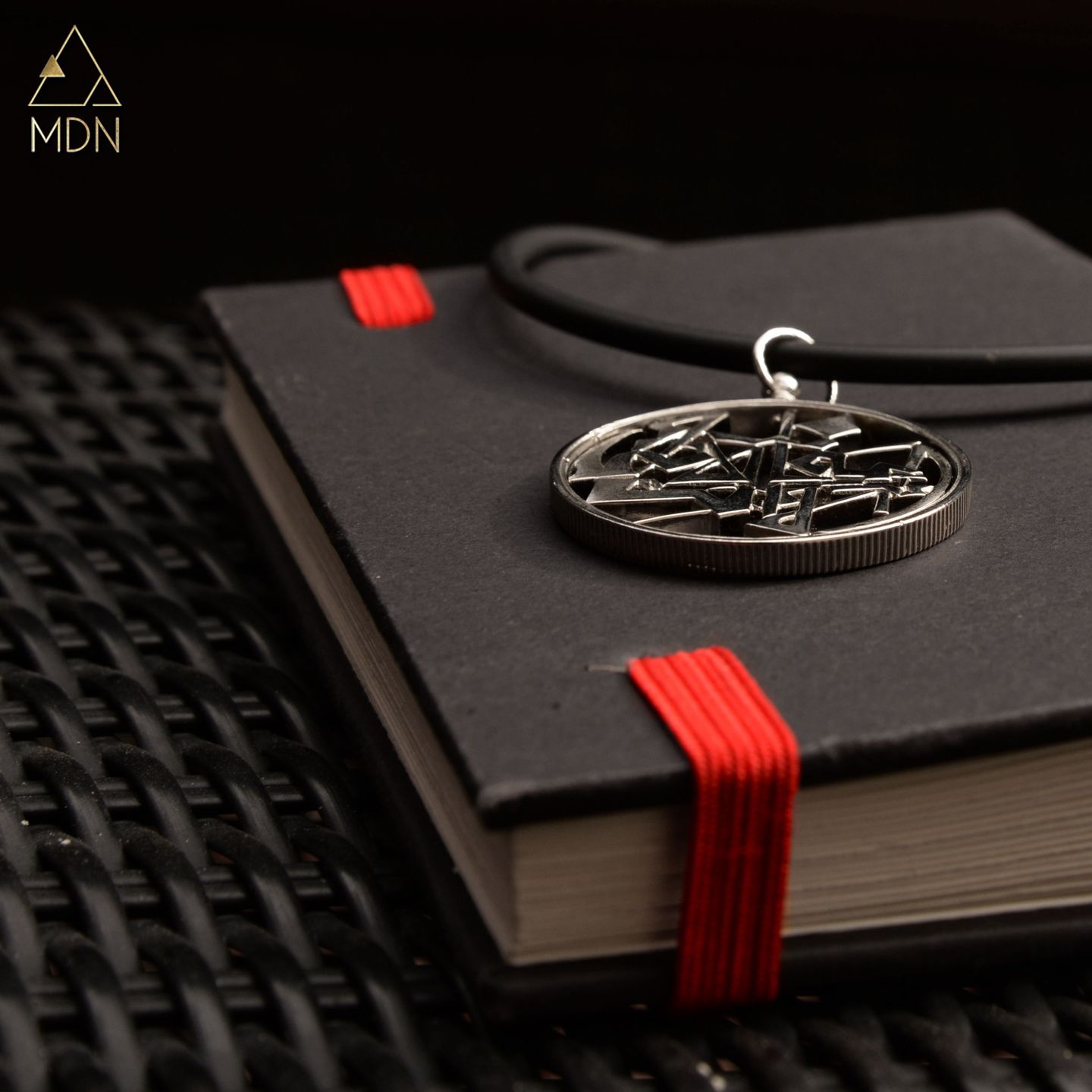 Pendant with Arabic calligraphy "الساعة الان انا الا انت" tied with red ribbon.
