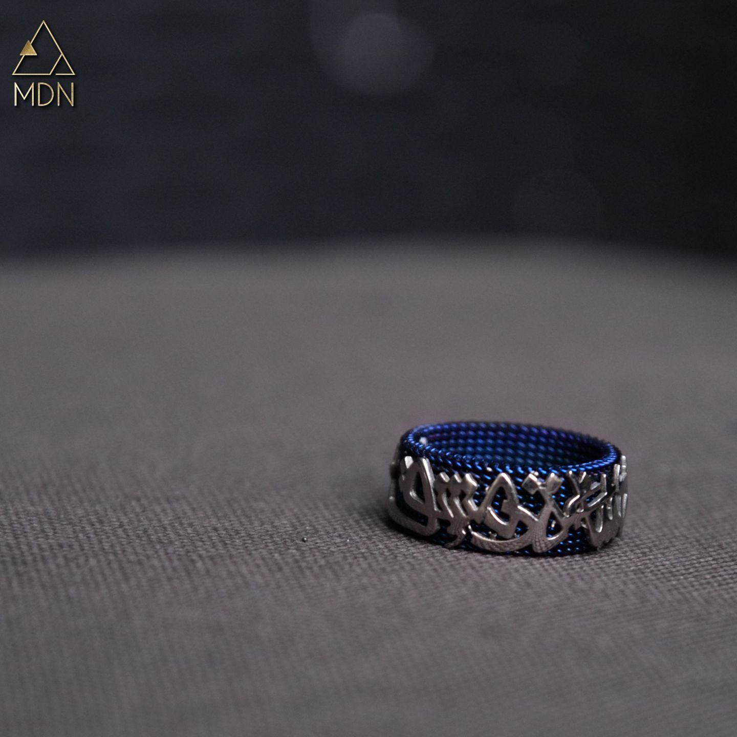 Ring with Arabic calligraphy "انا خاتم من صياغة دمشق" in blue.