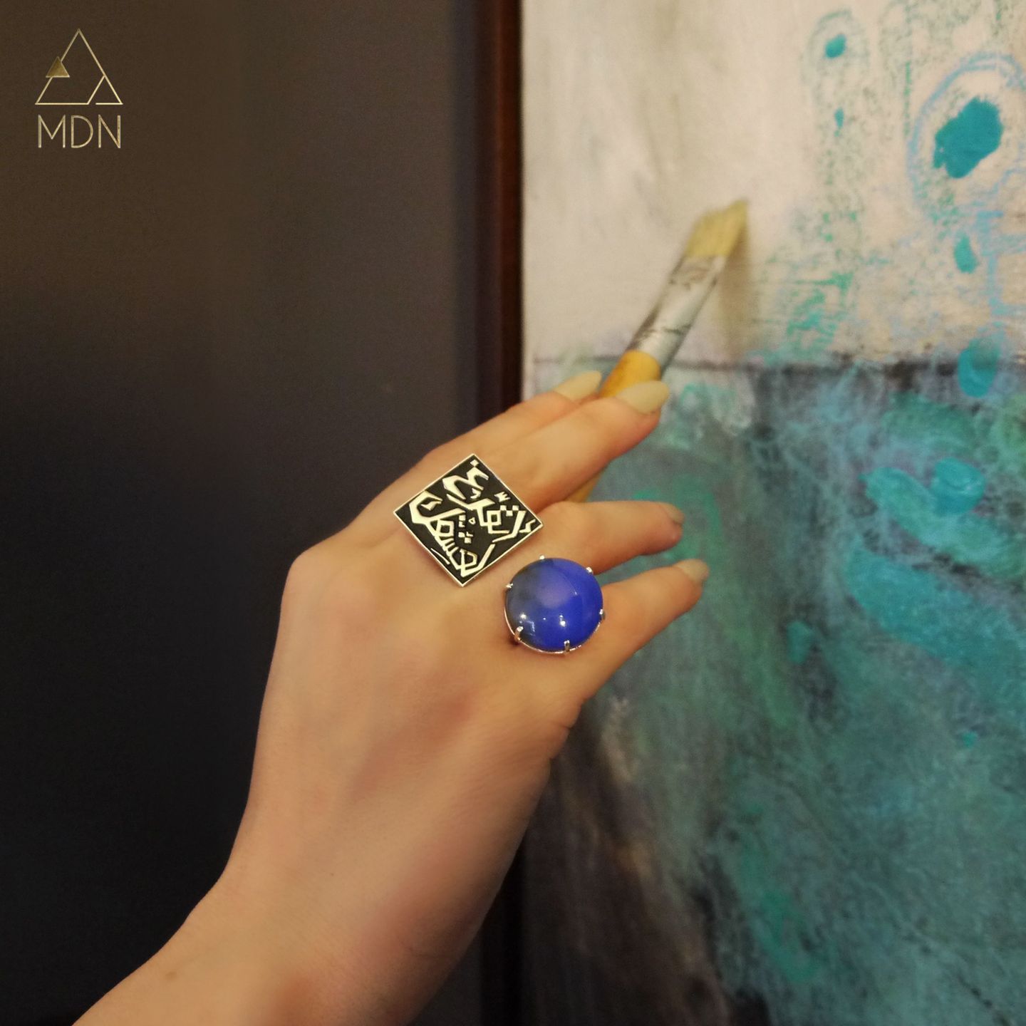Ring with Arabic calligraphy "اتفرغ لعشقك" and blue stone.