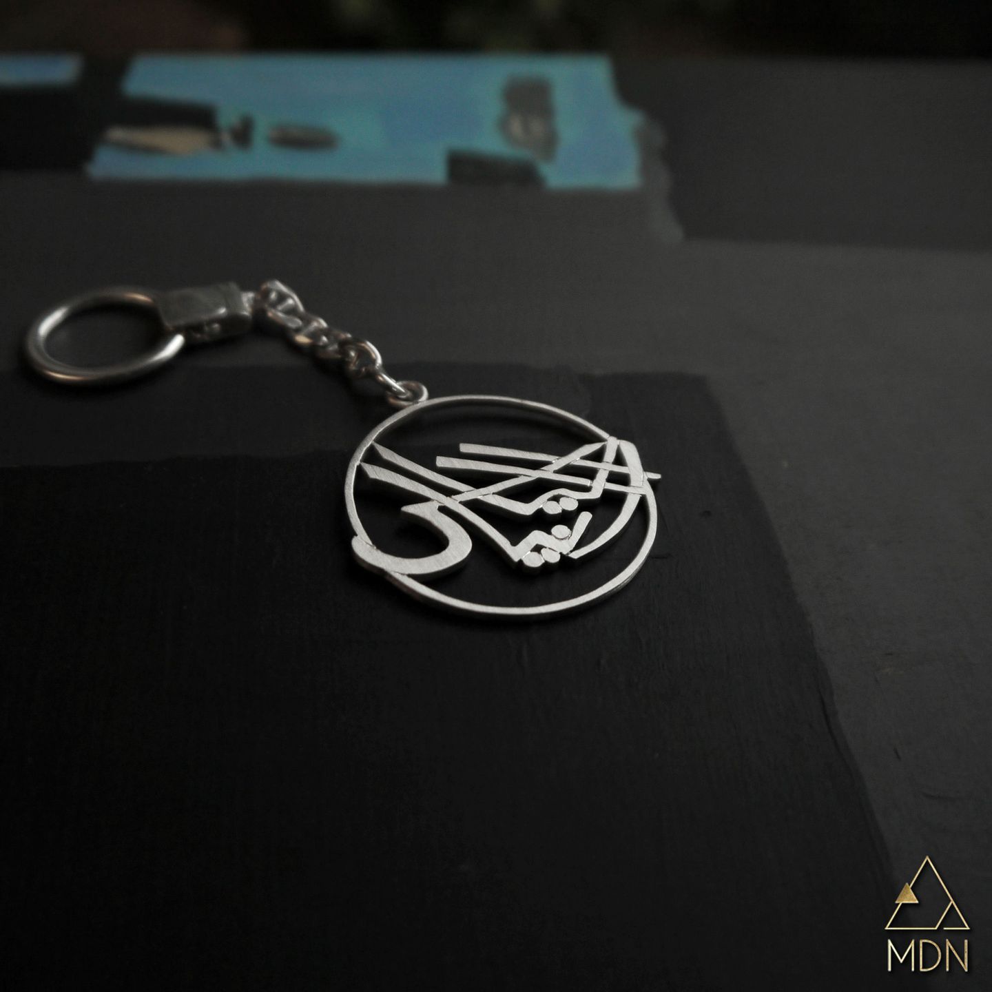 Keychain rendering the name Elias Rania in Arabic calligraphy.