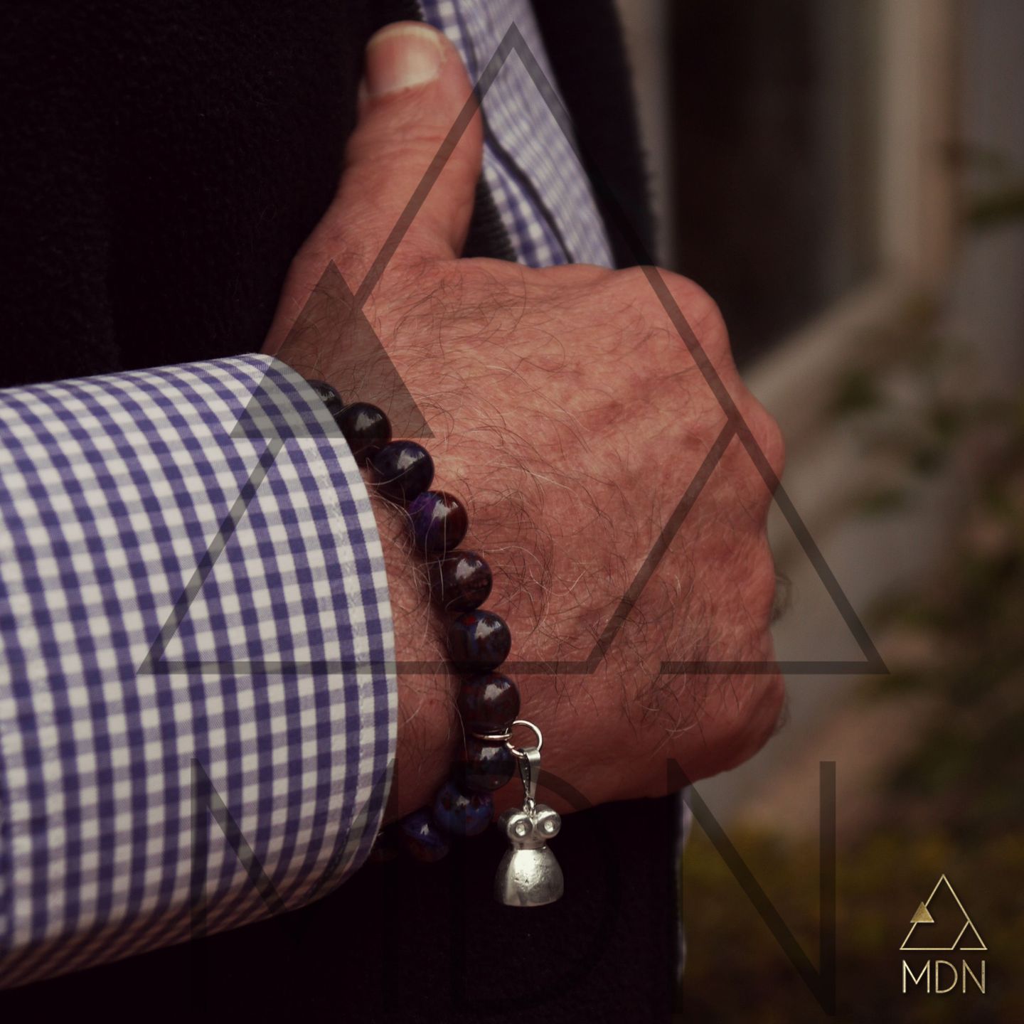Bracelet with black beads and metal pendant charm.