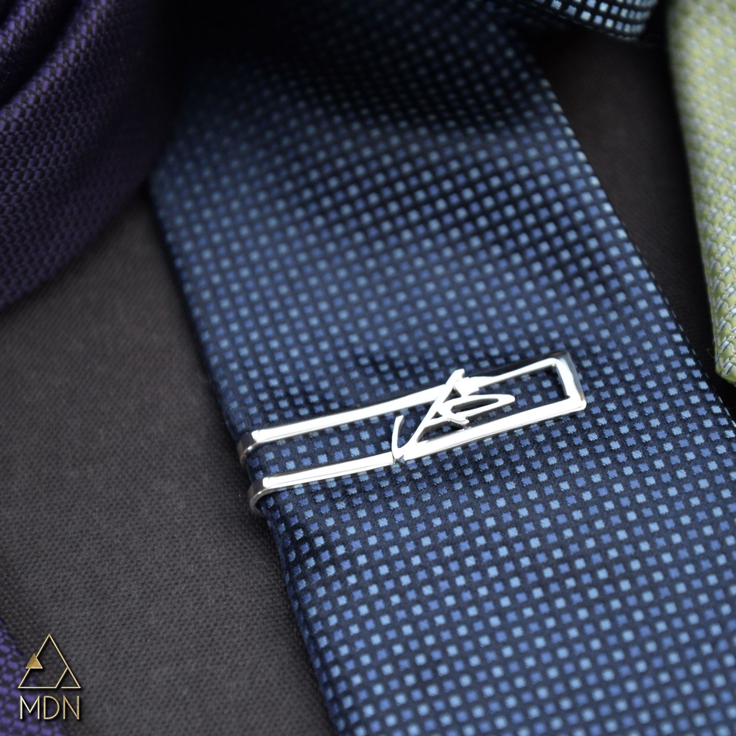 Rectangular tie clip with Arabic calligraphy reading "فل".