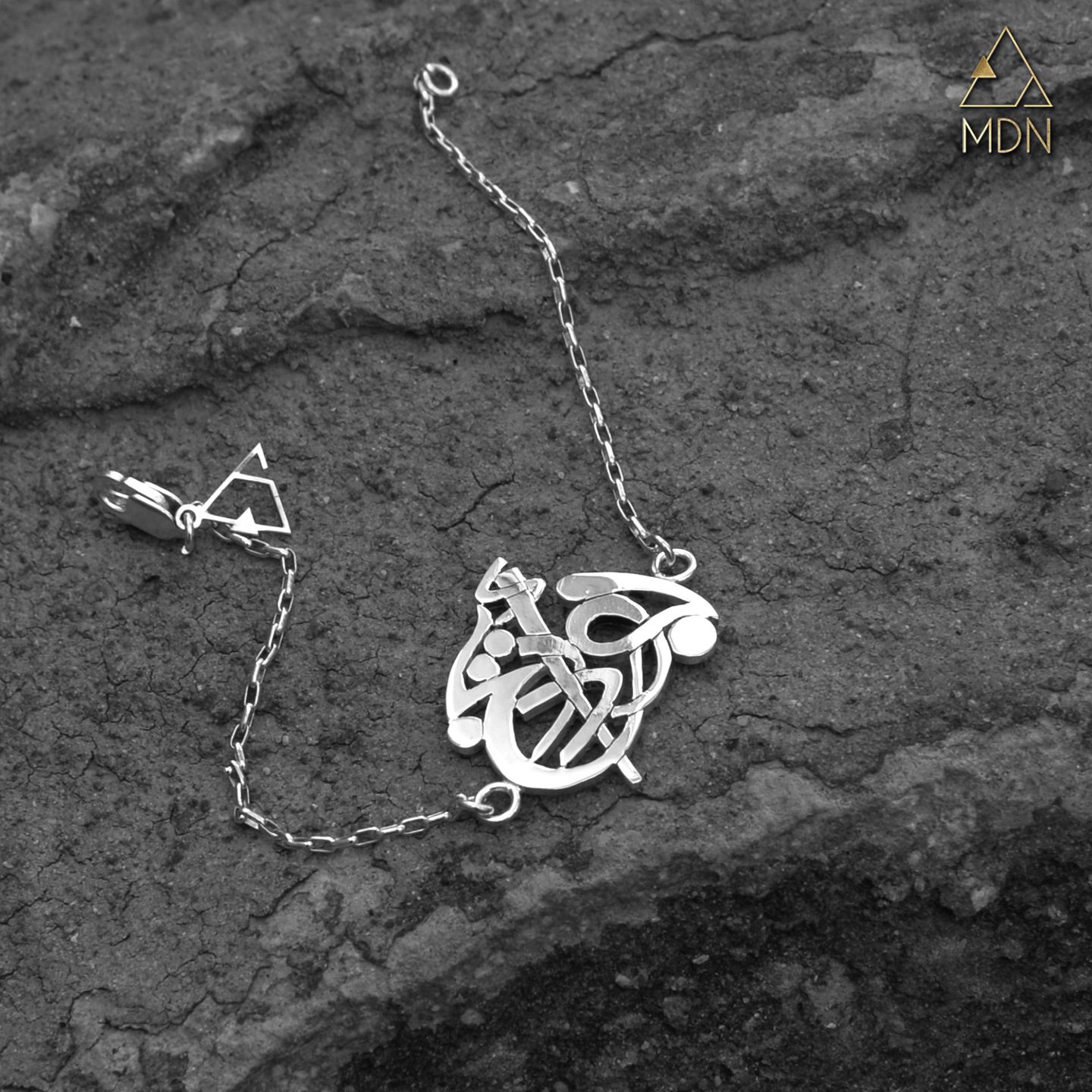 Pendant rendering the name Joud Areej in Arabic calligraphy.
