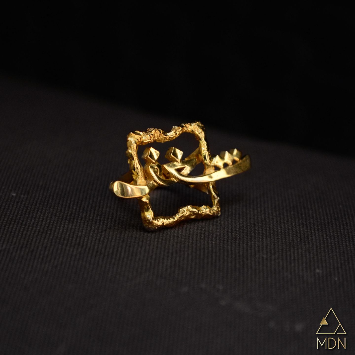 Gold-toned rectangular ring carrying Arabic calligraphy reading "شغف".