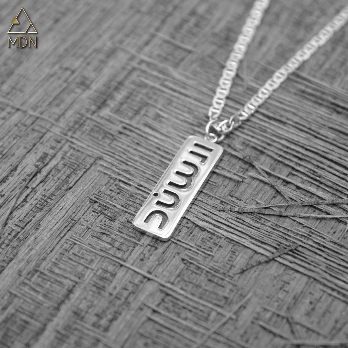 Pendant rendering the name Sanad in Arabic calligraphy reading "سند".